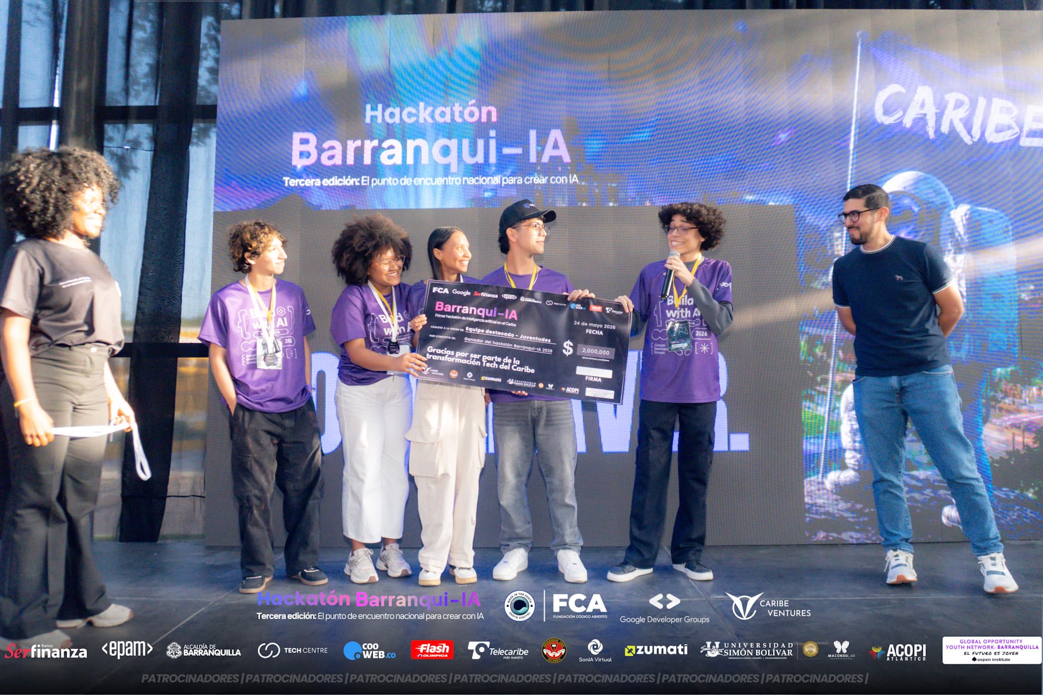 Equipo ganador en la tarima recibiendo su cheque simbólico durante la premiación de Barranqui-IA 2026